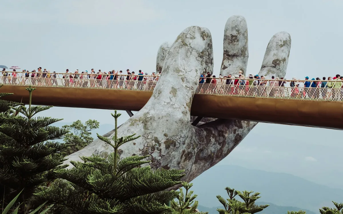 A large statue of a hand holding a bridge.